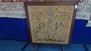 TWO VICTORIAN OAK FIRE SCREENS WITH FLORAL EMBROIDERY TO THE FRONT AND WOODEN PANELS TO THE BACK. (