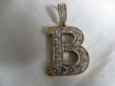 A 9ct GOLD PENDANT DEPICTING A `B` SET WITH SWAROFSKI CRYSTAL. 13.5 gms