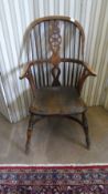 AN ANTIQUE OAK WHEEL-BACK WINDSOR ARMCHAIR ON TURNED LEGS UNITED BY A CURVED STRETCHER