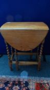 A SMALL GOLDEN OAK GATE LEG TABLE HAVING BARLEY TWIST SUPPORTS, APPROX. 89 X 60 X 78 cms