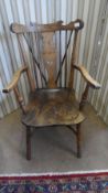 AN ANTIQUE ELM WHEEL AND SPINDLE BACK ARMCHAIR ON TURNED LEGS WITH A CURVED STRETCHER