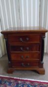 A MAHOGANY FOUR DRAWER BEDSIDE CABINET WITH EBONISED COLUMNS TO SIDE ON BRACKET FEET, APPROX. 57 x