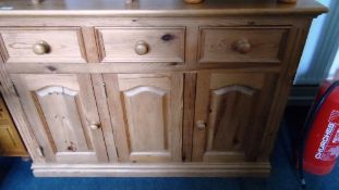 A MODERN PINE SIDEBOARD WITH THREE DRAWERS AND THREE CUPBOARDS BENEATH ON A PLINTH BASE, APPROX.