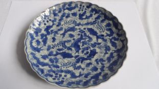 A BLUE AND WHITE CHINESE PLATE DEPICTING CARP AMONGST WATER REEDS WITH MARKS TO BASE.