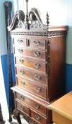 A MAHOGANY EFFECT CHEST ON CHEST HAVING A CHIPPENDALE STYLE FRIEZE TO THE TOP WITH A CARVED CORNICE,