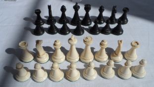 A SILK LINED CHINESE BOX WITH EBONY AND IVORY CHESS PIECES 31 pcs TOGETHER WITH A STONE CHESS BOARD