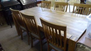 A SIX FOOT LONG OAK DINING TABLE TOGETHER WITH SIX MATCHING CHAIRS