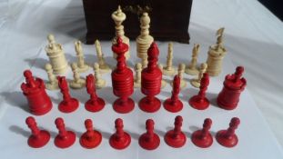 A VICTORIAN TURNED AND STAINED IVORY CHESS SET COMPRISING OF THIRTY-TWO PIECES IN ORIGINAL BLUE