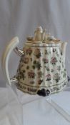 A PORTMEIRION FANCY TEAPOT HAVING FLORAL DESIGN AND MINIATURE TEA SET FOR LID.