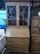 A Bespoke Oak Bureau Bookcase. The bookcase having glazed doors to the top enclosing two shelves,