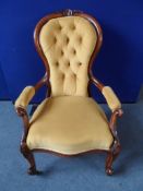 A Victorian Mahogany Button Back Elbow Chair, the chair with laurel leaf carving to front supports