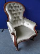 A Victorian Button Back Grandmother`s Chair. The mahogany chair on cabriole legs.