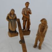 Three wooden hand carved figures including a woodcutter, an old woman and a nut cracker in the