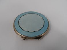 A Silver and Enamel Compact : a solid silver engine turned lady`s compact with blue enamel cover,