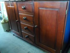 A Mahogany Sideboard. The sideboard having four drawers to the centre and a cupboard to each side.