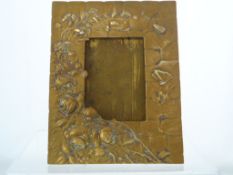 An Art Nouveau Brass Picture Frame. The frame depicting flowers and insects in relief.