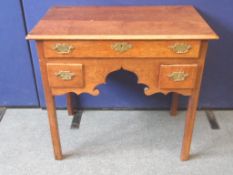 An Antique Possibly Georgian Oak Kneehole Writing Desk. The desk having one long and two short