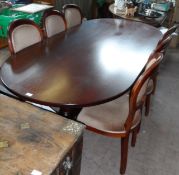 A Large Oval Mahogany Dining Table. The table being supported on two turned columns with splayed