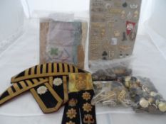 A Large Collection of Military Insignia. The box containing Sam brown belts, silk handkerchiefs (