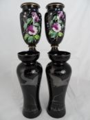 Black silver inlaid vases together with a pair of black porcelain vases depicting flowers. (4)