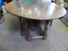 A Large Bespoke Oak Drop Leaf Dining Table. The oval table being on turned column supports united by