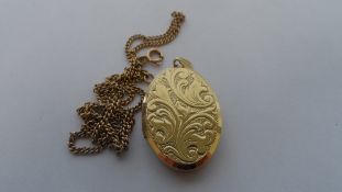 A 9ct HALLMARKED OVAL LOCKET WITH LAUREL LEAF DESIGN TO FRONT TOGETHER WITH 9 ct GOLD CHAIN. 12 gms