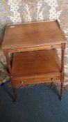 A VENEERED OCCASIONAL TABLE WITH PULL OUT SHELF UNDER THE TOP AND HAVING A SHELF AND A DRAWER BELOW,