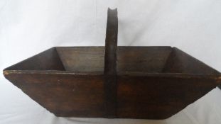 AN ANTIQUE OAK GARDEN TRUG HAVING A METAL HANDLE, APPROX. 49L X 34W X 30H ( TO THE TOP OF THE HANDLE