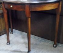 A MAHOGANY DEMI-LUNE HALL TABLE HAVING A SINGLE DRAWER AND BEING ON TURNED LEGS WITH PAD FEET