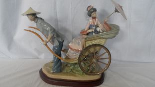 A LLADRO PORCELAIN STUDY OF A YOUNG WOMAN SEATED ON A RICKSHAW MODEL NR 1383 ON A WOODEN PLINTH,