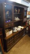 A YOUNGER TOLEDO OAK DRESSER HAVING TWO OPEN SHELVES AND A GLAZED CUPBOARD TO EACH SIDE WITH A