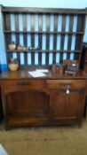 A LIBERTY`S STYLE ARTS AND CRAFTS OAK DRESSER HAVING A THREE SHELF PLATE RACK TO THE TOP, THE