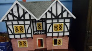 A TUDOR STYLE TWO BEDROOM DOLLS HOUSE HAVING MISC. DOLLS HOUSE FURNITURE, APPROX. 75 X 35 X 58 cms