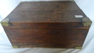 AN ANTIQUE OAK SEWING BOX HAVING BRASS MOUNTS TO THE CORNERS AND BRASS HANDLES TO THE SIDES TOGETHER