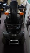 A BLACK FOUR WHEEL MOTABILITY SCOOTER WITH INDICATORS AND HEAD LIGHTS, APPROX. NEW COST £2000