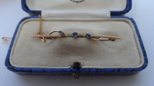 A LADY`S 9ct GOLD BAR BROOCH SET WITH SAPPHIRES TOGETHER WITH GOLD SAFETY CHAIN IN ORIGINAL BOX.