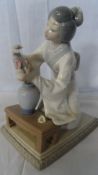 A LLADRO PORCELAIN FIGURINE OF A `GEISHA FLOWER ARRANGING` NR KT89PE, 20 cms.