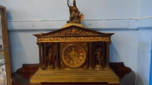 A METAL CASED MANTLE CLOCK IN THE GRECO / ROMAN STYLE HAVING A FIGURE OF BOADICEA TO THE TOP WITH