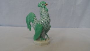 A PORCELAIN COCKEREL BY HEREND OF HUNGARY, IN TYPICAL GREEN PALETTE, WITH PRINTED AND IMPRESSED