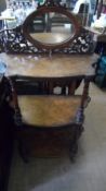 AN EDWARDIAN INLAID WALNUT THREE TIER WHAT NOT HAVING AN OVAL MIROR TO THE TOP SURROUNDED BY PIERCED