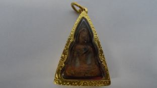 AN ANTIQUE STONE THAI BUDDHA ENCASED IN A HAND ENGRAVED 18ct + TESTED GOLD PENDANT SETTING