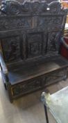 A 17TH CENTURY STYLE CARVED OAK SETTLE WITH DRAGONS AND CARVED LION HANDLES. 121 X 137 X 137 cms.