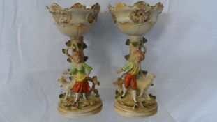 A PAIR OF ANTIQUE PORCELAIN SWEET MEAT DISHES ON STANDS DEPICTING A SHEPHERD AND SHEPHERDESS, THE