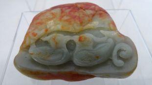 A GREEN JADE CARVING DEPICTING TWO ENTWINED BIRDS BENEATH THE SUN. (9 X 8 cms)