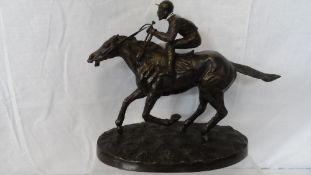 A COLD CAST METAL FIGURE OF A RACEHORSE AND JOCKEY, APPROX. 26 cms LONG AND 21 cms HIGH