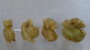 FOUR PIECES OF GREEN JADE INCLUDING TWO PHOENIX WITH PIERCED LOOP HOLES , A SEA SERPENT AND A