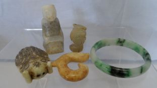 FOUR HARD STONE CARVINGS INCLUDING A KNEELING FIGURE, TWOSEASERPENT, CICADA AND A GREEN JADITE