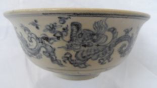 AN ANTIQUE BLUE AND WHITE BOWL DEPICTING CHASING DRAGONS AND ONE SINGLE DRAGON TO THE INTERIOR.