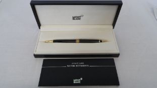A BLACK AND GOLD PLATED MONT BLANC BALL POINT PEN IN ORIGINAL BOX.