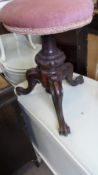 A VICTORIAN CIRCULAR PIANO STOOL ON A DECORATIVE CENTRAL MAHOGANY COLUMN AND THREE SPLAYED FEET.